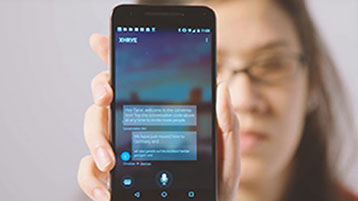 Seorang wanita yang memegang teleponnya ke kamera yang menunjukkan fitur live Translator dalam tindakan