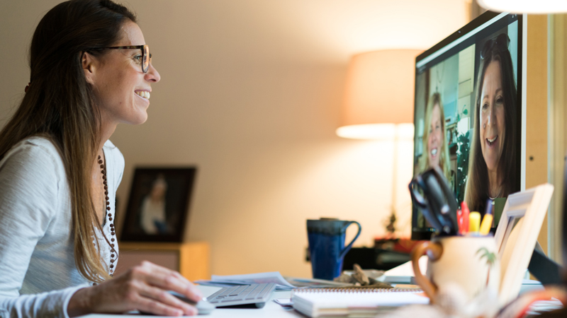 Une femme utilisant la vid&eacute;oconf&eacute;rence Skype pour assister &agrave; une r&eacute;union de travail