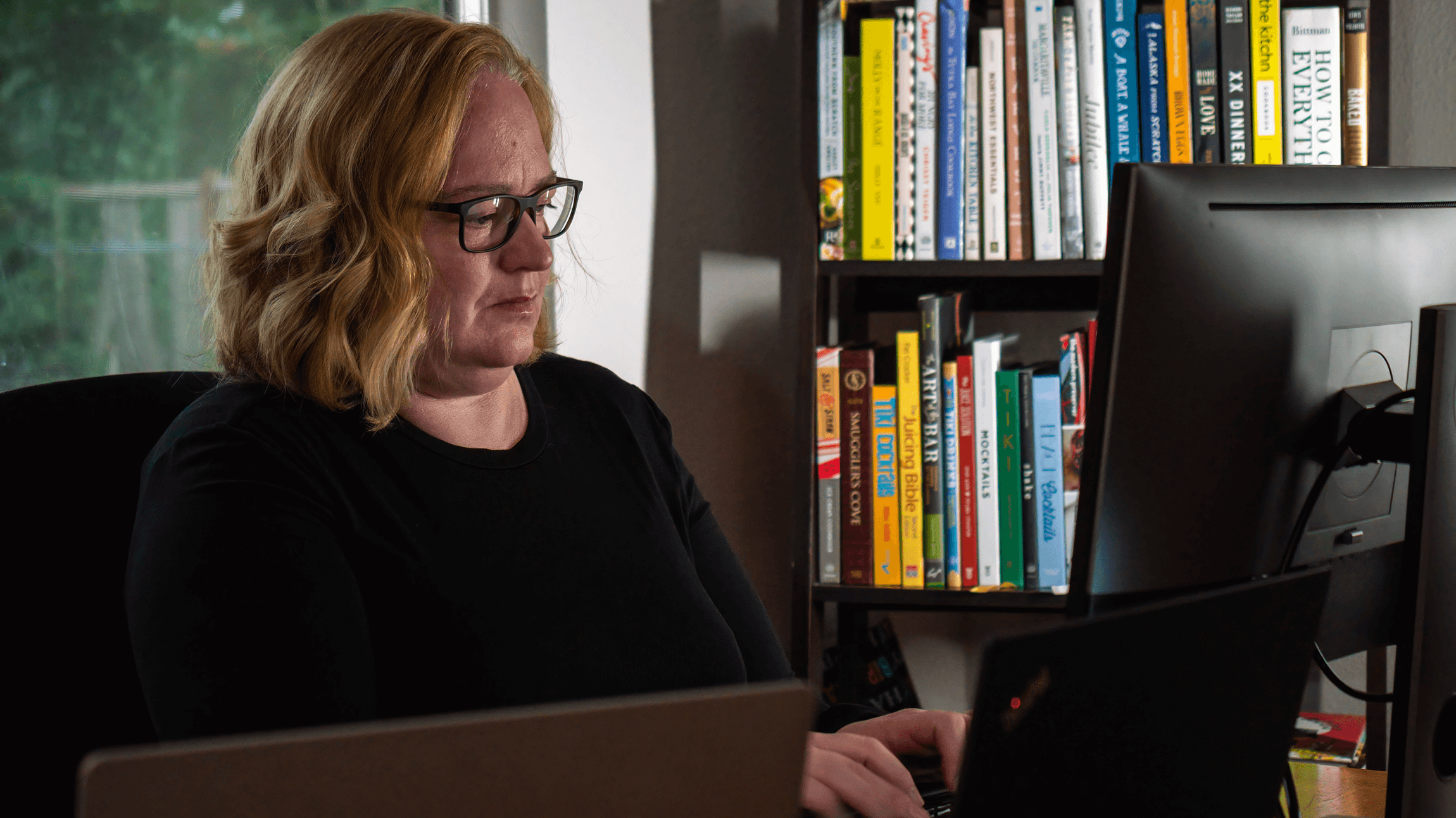 Garrison works on a PC at her desk.