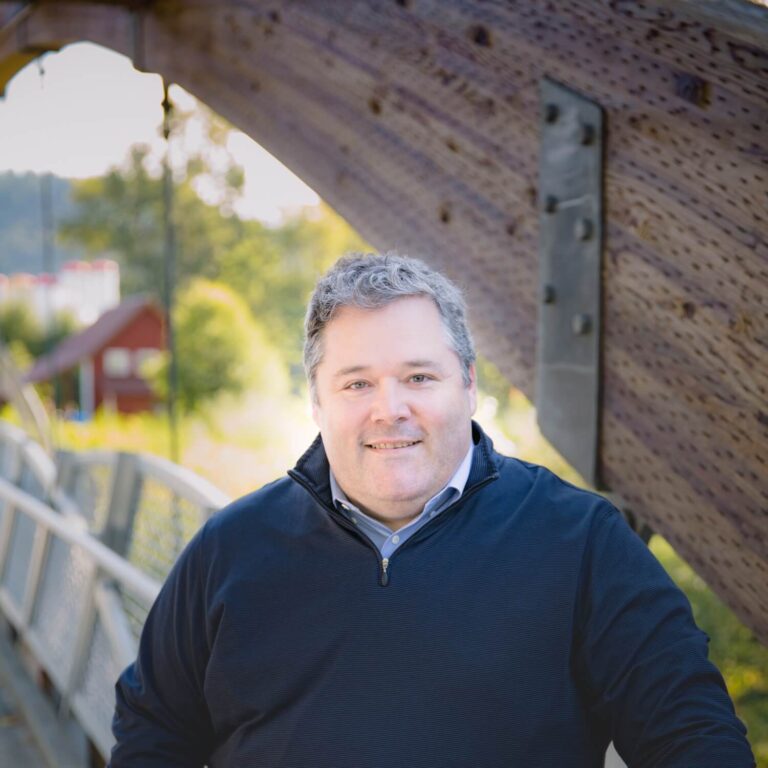 Pelland smiles as he stands for a portrait photo outside.