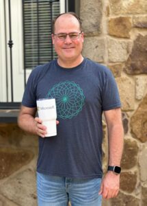 Morgan smiles with a Microsoft coffee cup in a posed portrait.
