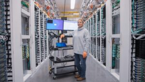An employee in a Microsoft datacenter looks up from her mobile workstation.