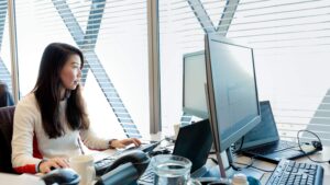 A Microsoft employee works at her desk in an open space working arrangement.