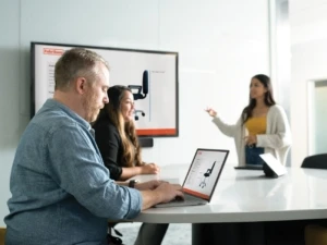 会議室の大型ディスプレイをPCと連動させて製品を検討する男女