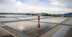 屋上ソーラーパネル上に立つ男性作業員