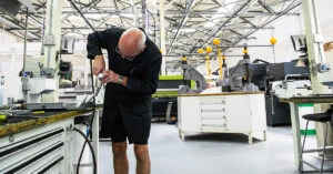 F1 の製造工場でレーシング カーのパーツが手作業で組み立てられている様子