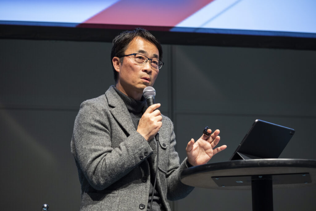 壇上にて講演を行う男性