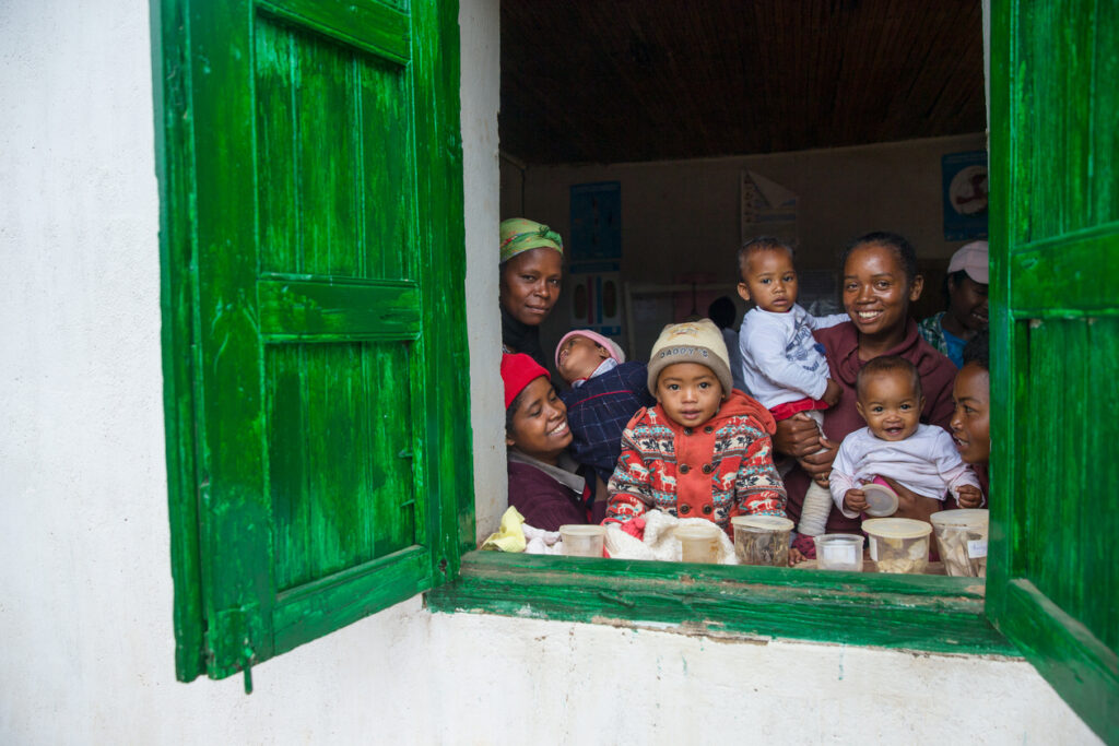 窓から外を覗く母親とその子供達