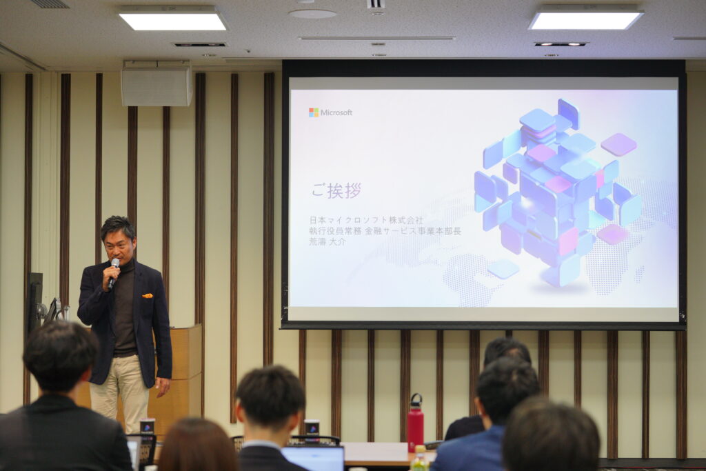 A man standing in front of a large screen