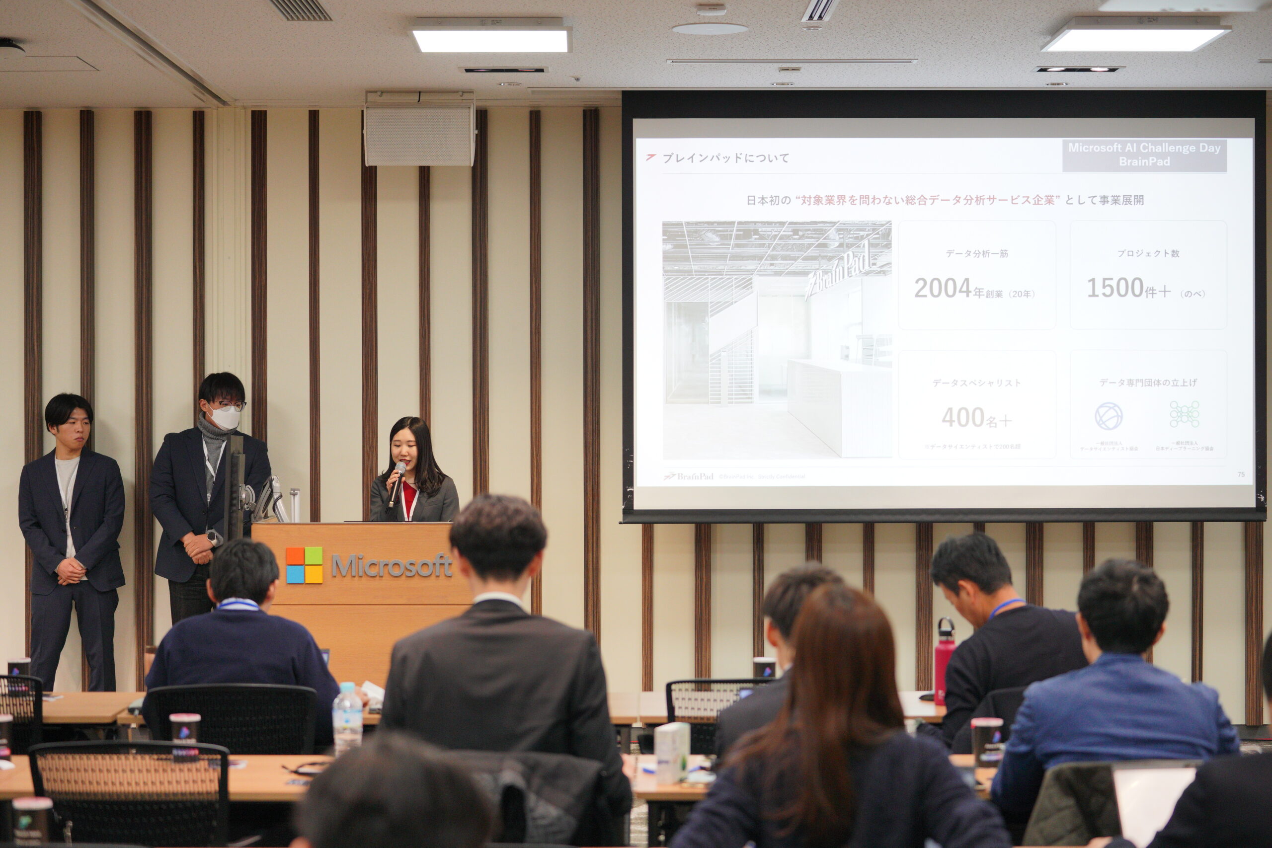 A group of people in a room with a projector screen