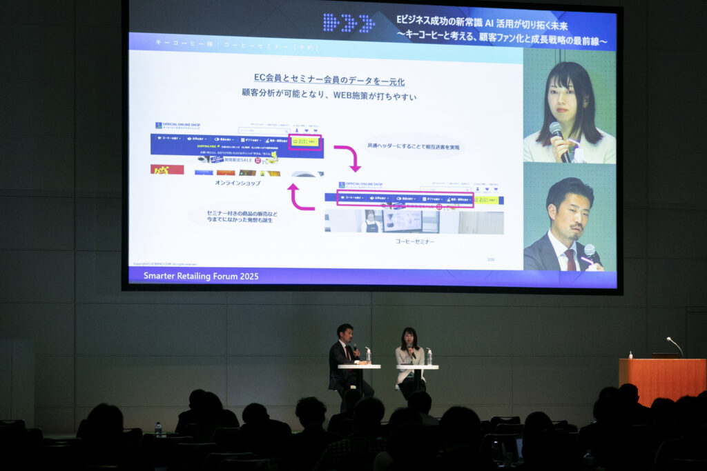 A man and woman standing at a podium with a large screen