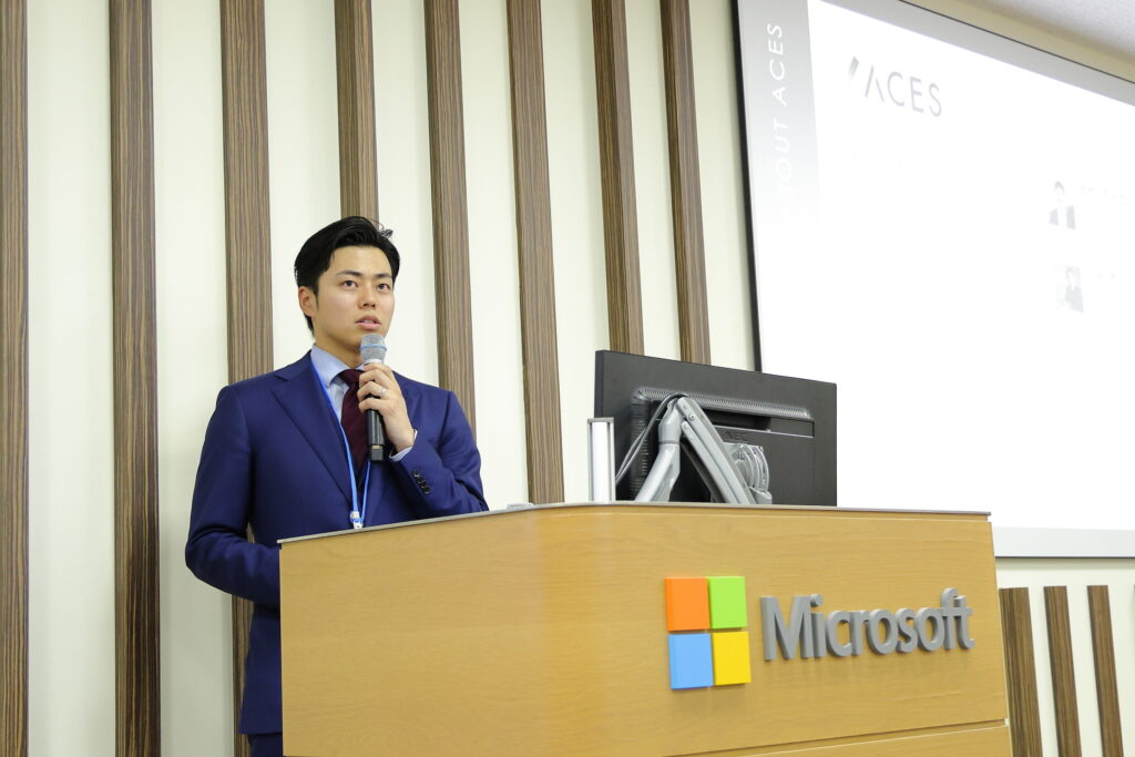 A man in a suit standing at a podium holding a microphone
