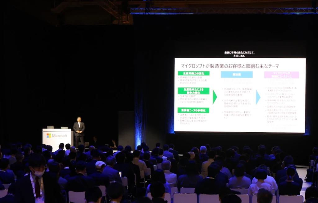 A man standing in front of a large screen