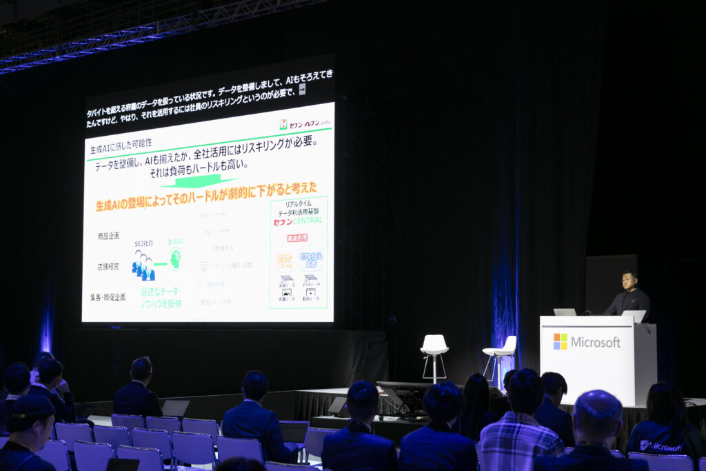 A group of people sitting in chairs in front of a large screen