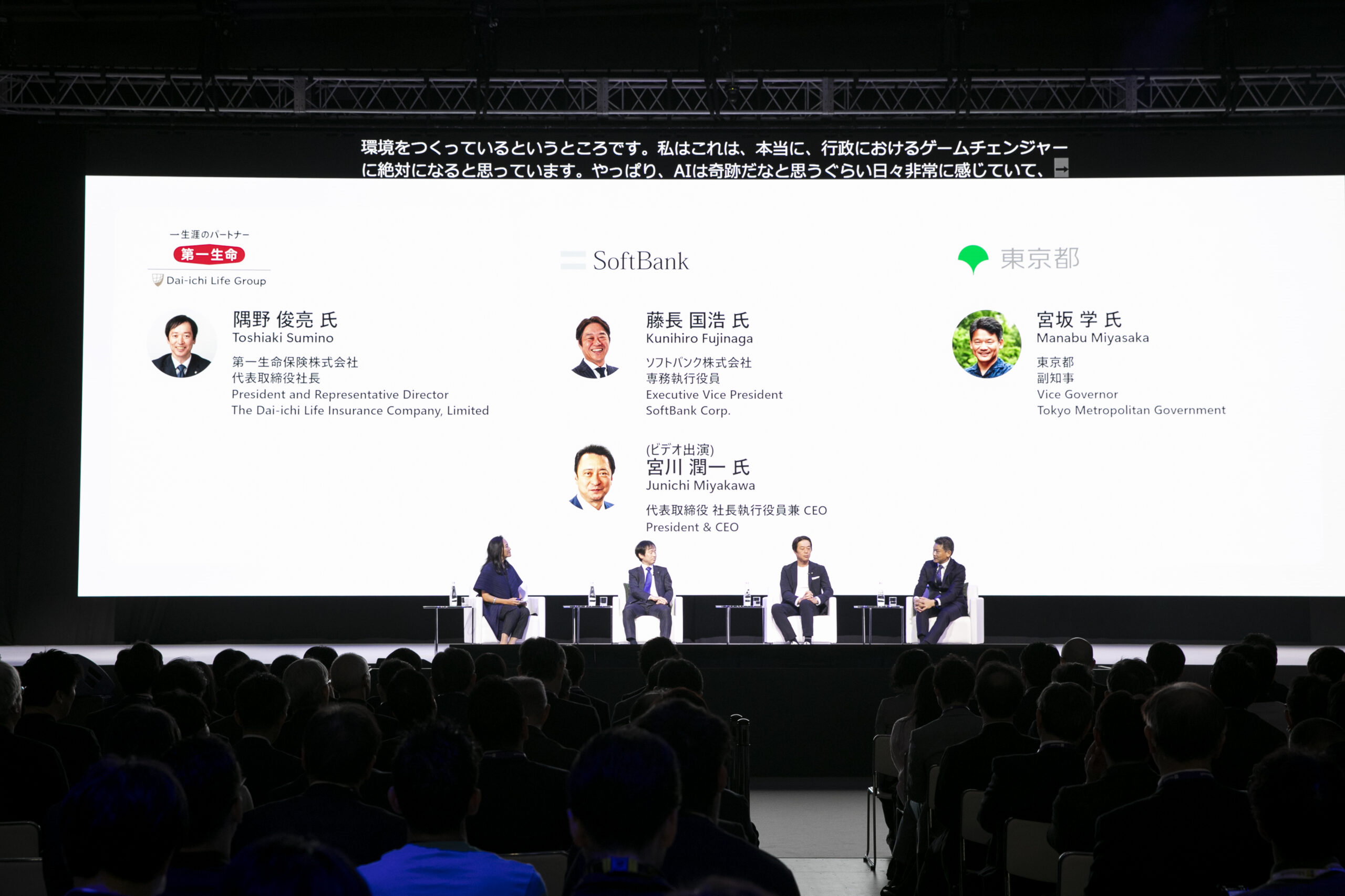 A group of people sitting in front of a large screen