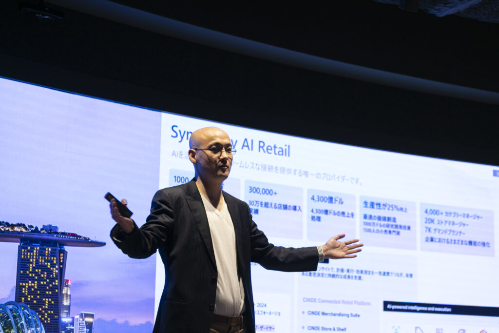 A man standing in front of a large screen