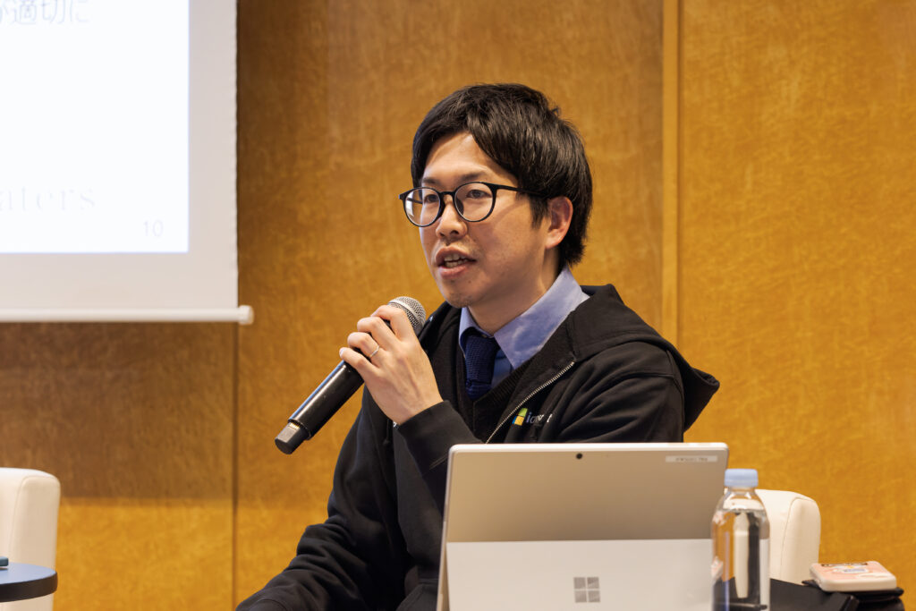 A man in glasses holding a microphone