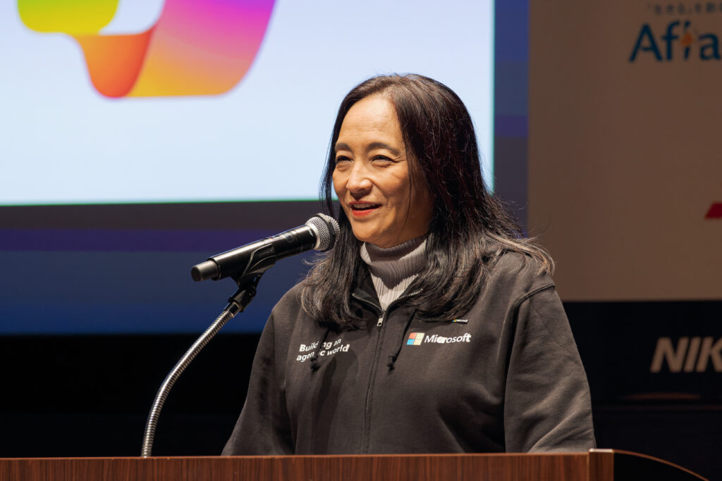 A woman standing at a podium with a microphone