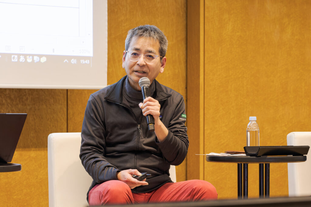 A man sitting in a chair holding a microphone