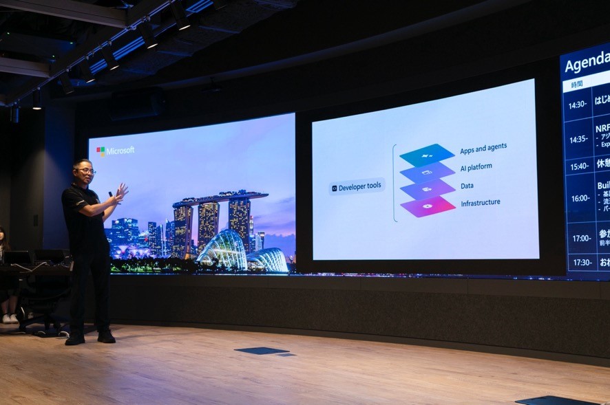 A woman standing in front of a large screen