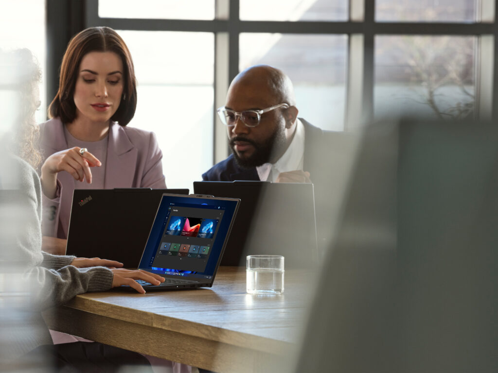 A group of people sitting at a table with laptops