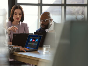 A group of people sitting at a table with laptops