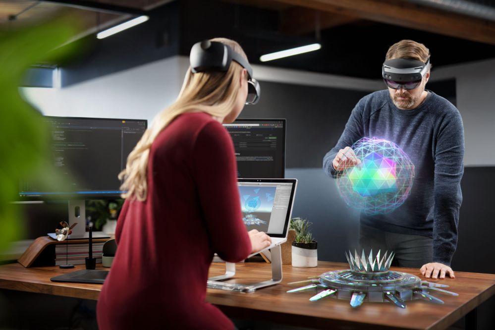 ラップトップで作業する HoloLens 2 デバイスを装着した男女