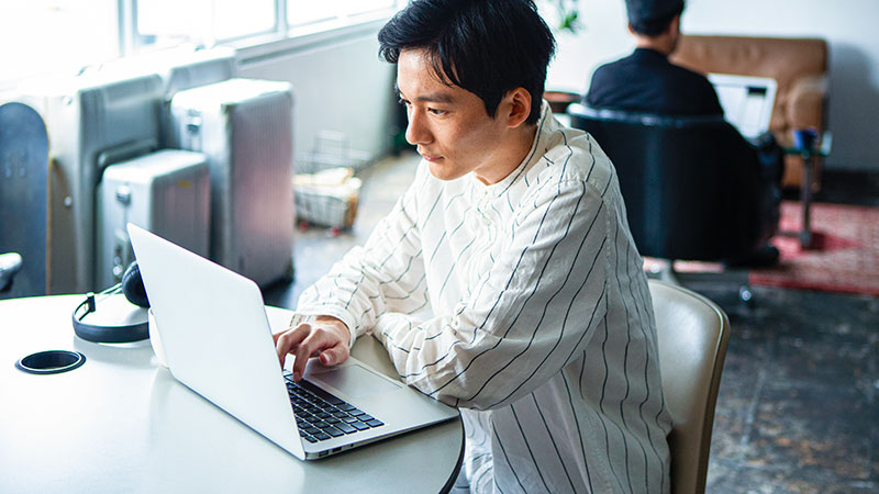 共有スペースでパソコン作業をする男性