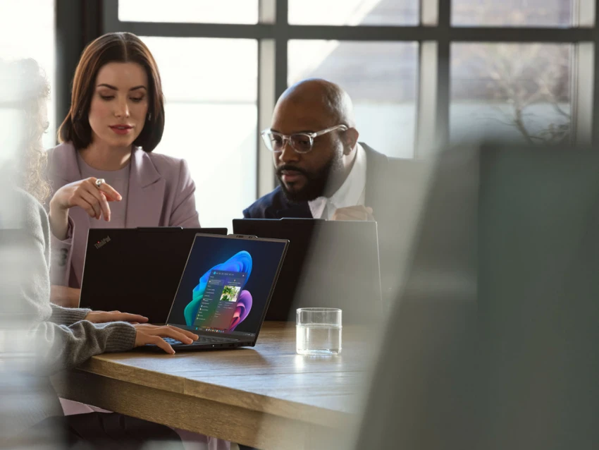 A group of people sitting at a table with laptops