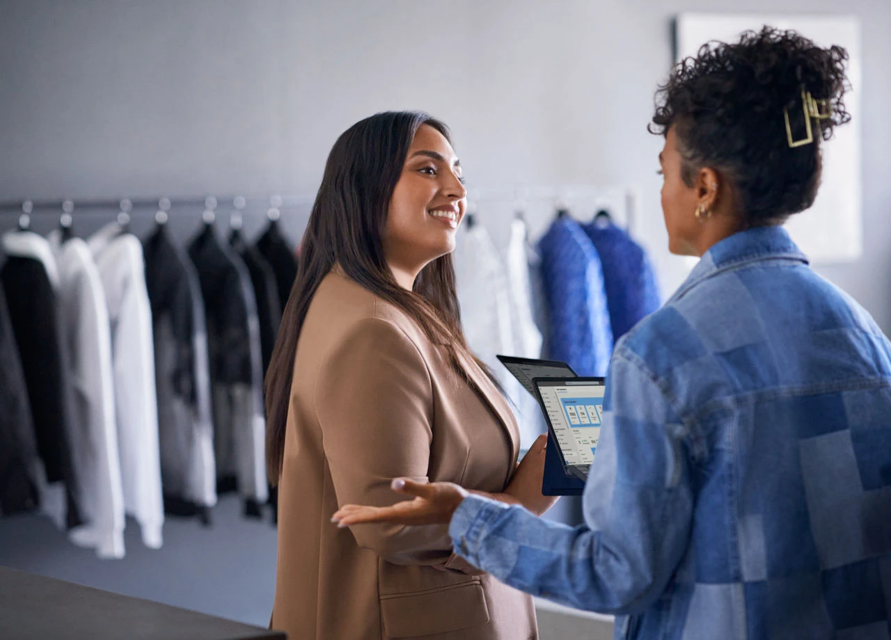 Retail business operations manager reviewing real time data with employee