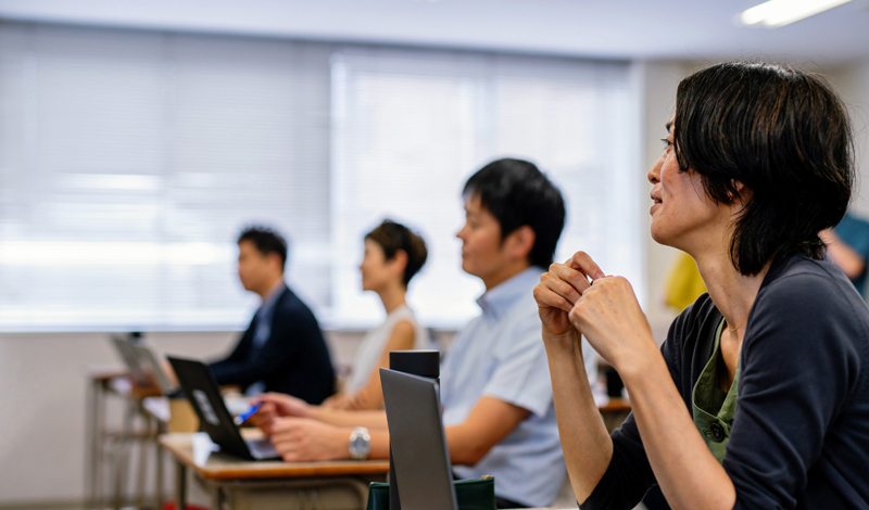 Pessoas em uma sala de aula com notebooks nas carteiras