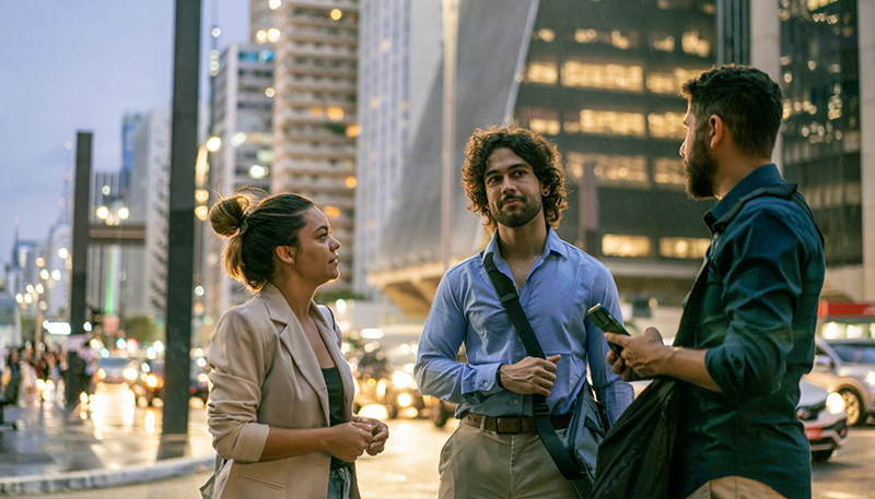 dois homens e uma mulher em pé com a avenida Paulista ao fundo.