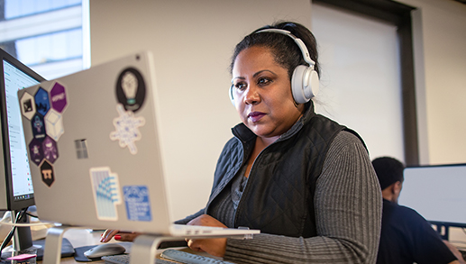 Pessoas reais, escritórios reais. Desenvolvedora escreve no quadro branco durante uma reunião de equipe.