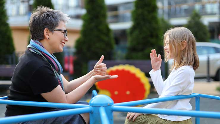 woman and young child doing sign language to each other